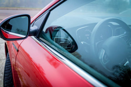 new car sedan red color is parked autumn park